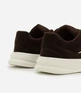 Championes de estilo skater para hombre, confeccionados en poliuretano color tostado. Poseen punta redonda, caña baja, suela alta blanca y cierre mediante cordones anchos tipo fat lace. Incluyen recortes y detalles contrastantes en los laterales.