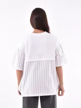 Remera blanca de corte holgado con mangas cortas y detalle de rayas verticales negras en mangas y laterales.