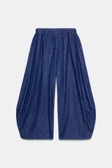 Pantalón de denim azul con cintura elástica ajustable con cordones interiores y pierna ancha con volumen.