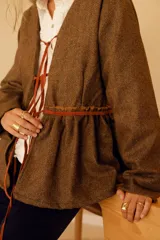 Chaqueta marrón de lana con forro de algodón y tiras de cuero. Diseño con cuello en V y corte a la cintura.