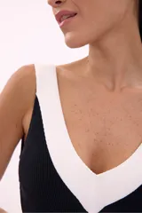Traje de baño enterizo negro con escote en V y ribete blanco.