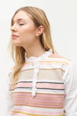 Blusa rosada con mangas largas, cuello con volados y estampado de líneas verticales.