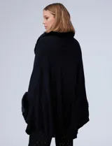 Ruana tejida color crema de la marca Adrienne Vittadini, con cuello, delantera y puños con aplique en símil piel. Delantera con abertura central y botón trenca.