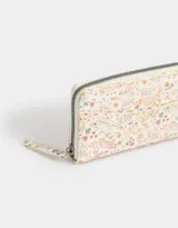 Billetera con cierre, formato fichero, de cuerina color crudo con estampado de flores y cachemir.