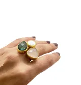 Anillo artesanal con engarce dorado, con tres piedras irregulares: una perla barroca, un cuarzo rosa facetado y una piedra de la luna. El tamaño es regulable.