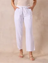 Pantalón largo de lino y rayón a rayas verticales grises y blancas. Tiene pretina elastizada con lazo de ajuste, bolsillos delanteros y traseros.
