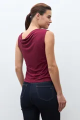 Top sin mangas color bordó con escote drapeado tipo cascada, ajustado al cuerpo.