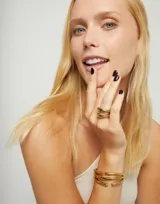 Anillo dorado con forma de tubos entrelazados, bañado en oro de 18k.