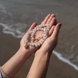Collar con cuentas de piedra de la luna de 8 mm de diámetro, separadores de hilo azul, cierre y dije de caracol con baño de oro.