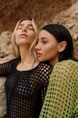 Vestido corto negro tejido a crochet con mangas largas y espalda descubierta.