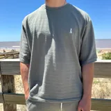 Remera blanca de tejido texturizado con cuello redondo y manga corta.