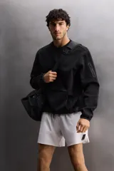 Shorts deportivos color verde oliva confeccionados en tejido técnico ligero y elástico. Cuenta con forro interior, cintura elástica ajustable con cordón, bolsillos laterales, bolsillo de seguridad en espalda con cierre de cremallera, bajo con aberturas laterales y logo estampado en la pierna.