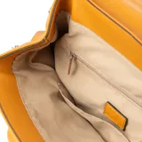Mochila color camel de símil cuero acolchado, con acceso mediante solapa con botones imantados. Tiene un compartimento principal con un bolsillo interno con cierre y dos bolsillos abiertos. Cuenta con correa regulable y herrajes plateados.