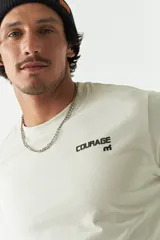 Remera de manga corta color ladrillo, con cuello redondo y estampado con texto y diseño abstracto en el frente.