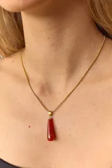 Collar dorado con cadena fina y dije colgante en forma de lágrima de piedra natural azul con vetas blancas.