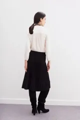 Falda midi negra de tejido de punto con cintura elastizada y diseño plisado.