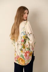 Blusa color crema con estampado floral y detalles de diseño barroco, con cuello mao, mangas 3/4 y cierre frontal con botones.