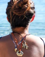 Collar con dije de bronce macizo con forma orgánica o de coral, suspendido de un hilo de seda natural color naranja.