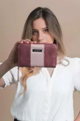 Billetera mediana de símil cuero combinada en dos tonos, color borgoña y rosa pálido. Tiene compartimento interior con tarjeteros y cierre interior. Monedero con cierre alrededor.