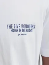 Remera blanca de manga corta y cuello redondo, con fit relajado. Presenta un pequeño estampado negro en el pecho con el texto "THE FIVE BOROUGHS HIDDEN IN THE HEIGHTS".