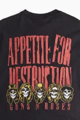 Remera negra de corte holgado con estampado frontal del logo de la banda Guns N' Roses en color rojo.