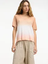 Remera color durazno con degradé blanco, de punto con escote en V y mangas cortas.