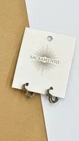 Par de aros de acero plateado con forma de corazón.