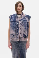 Chaleco de jean azul con efecto lavado, corte oversized y bolsillos delanteros.