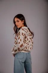 Sweater de punto color crudo con estampado animal print marrón.