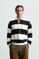 Sudadera azul marino de corte regular con cuello polo blanco de solapa y cierre frontal de botonadura oculta.