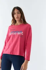 Remera fucsia de algodón con mangas largas, cuello redondo y estampado con la frase "always true art" en azul y blanco.