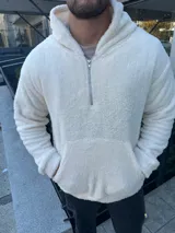Canguro blanco de tela tipo peluche con cierre parcial y bolsillo tipo canguro.