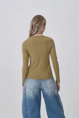 Remera de manga larga ajustada al cuerpo, color negro, con cuello redondo a la base y tejido acanalado.