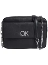 Cartera cruzada rectangular de Calvin Klein, color negro, con textura granulada en el exterior. Presenta un bolsillo frontal con cierre giratorio y el monograma metálico 'CK'. La correa es ajustable y combina una sección de cuero sintético negro con una cadena metálica plateada.