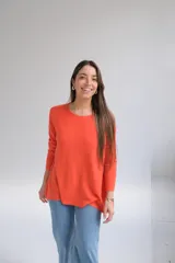 Sweater naranja de tejido de punto, corte recto, cuello redondo y mangas largas. El frente es más corto que la parte trasera y tiene aberturas en la espalda.
