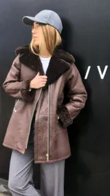 Chaqueta marrón gastado de cuero ovino con cuello y puños de piel sintética color crudo. Cierre frontal con cremallera y bolsillos laterales.