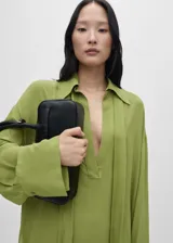 Camisa oversize verde manzana de gasa con lazo en el cuello y aberturas laterales.