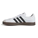 Championes Adidas VL Court Base blancos con detalles en negro y suela marrón. Presentan las tres tiras características de la marca en los laterales y puntera de gamuza gris.