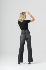 Pantalón de jean negro de tiro alto, corte recto y diseño de piedras en el lateral de las piernas.