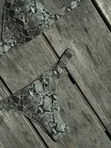 Conjunto de bikini turquesa con corpiño triangular de corte fijo, breteles regulables y almohadillas desmontables, y bombacha vedetina con frunce elástico en los costados.