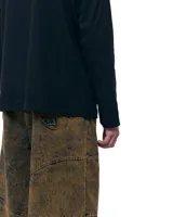 Pantalón unisex de denim 100% algodón con acabado marmolado color bronce. De tiro medio y calce wide/relajado, con pierna muy amplia y caída larga. Cintura con elásticos laterales, costuras curvas y bolsillos delanteros y traseros con bocas redondeadas.