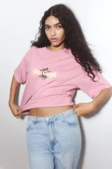 Remera rosa de corte amplio con estampado de girasoles y el texto "Van Gogh".