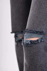 Pantalón de jean gris oscuro de corte recto con roturas en las rodillas.