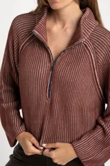 Sweater de punto morado con cierre metálico parcial en el cuello alto y mangas largas.