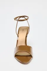 Sandalias color caramelo de charol con tira delantera, pulsera tobillera con hebilla y tacón fino alto.