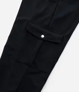 Pantalón cargo negro de crepé, talle grande, con bolsillos laterales con botón y cintura lisa.