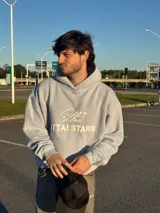 Buzo hoodie celeste con bolsillo tipo canguro y estampado frontal con el logo de la marca en blanco.