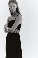 Vestido midi negro con breteles finos ajustables, escote recto, cuerpo ajustado con punto smock y falda con vuelo.