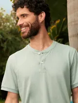 Remera verde agua de manga corta con cuello redondo y tapeta con dos botones.