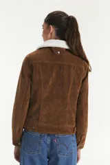 Campera Levi's color marrón con forro de sherpa blanco en el cuello. Es de gamuza sintética con cierre de botones y bolsillos en el pecho.